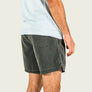 Person wearing gray shorts and a light blue shirt on a plain background