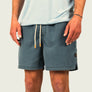 Person wearing blue shorts with a white background