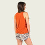 Back view of person wearing a burnt orange tank top with camo shorts against a blank background