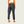 Person wearing dark gray jogger pants on a plain background