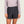 Person wearing shorts and a light purple top against a white background