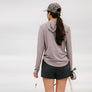Person wearing grey shorts with a fishing pole against a white background