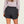 Person wearing grey shorts with a pocket on the back against a white background