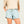 Person wearing a frosty green pair of patterned shorts with a plain background