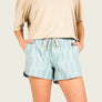 Person wearing a frosty green pair of patterned shorts with a plain background