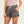 Person wearing camouflage shorts on a plain background