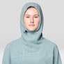 Person wearing a light blue hooded garment against a plain background