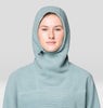 Person wearing a light blue hooded garment against a plain background