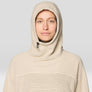 Person wearing a beige hooded garment against a plain background