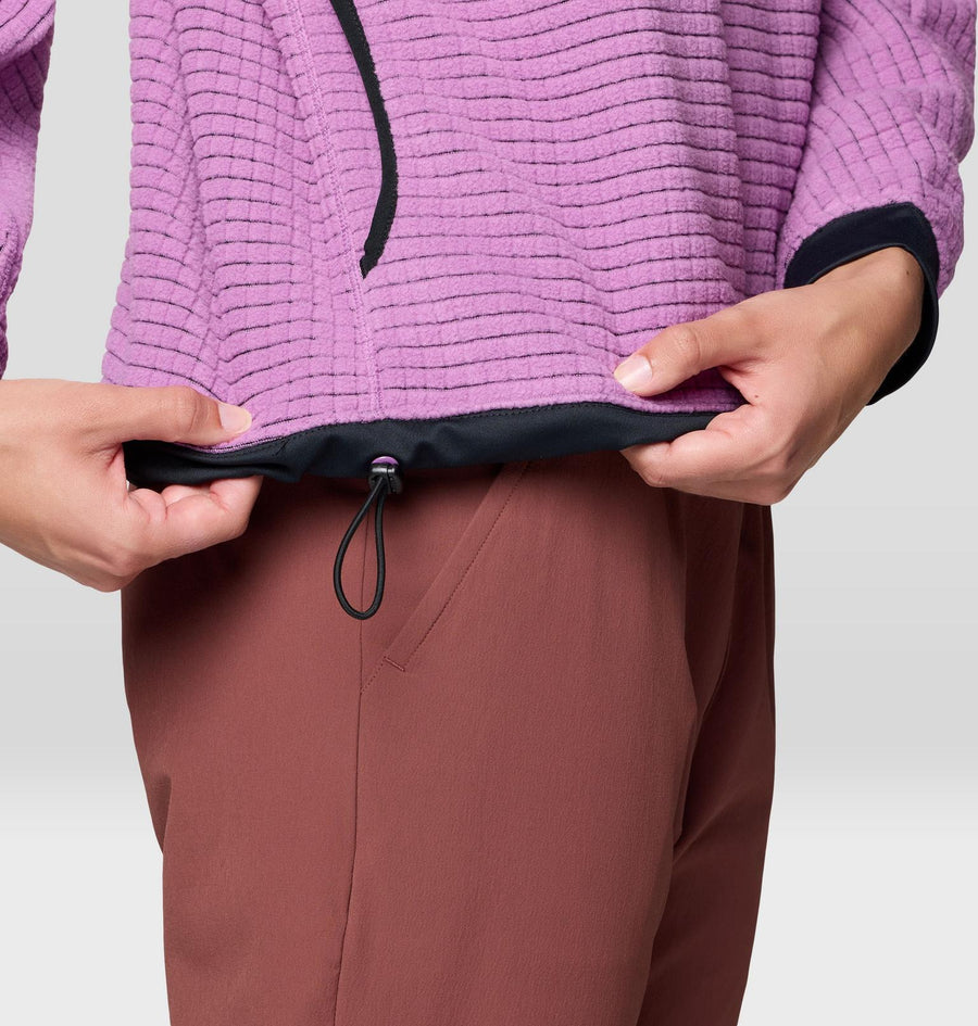 Person wearing a purple textured jacket with a drawstring, on a plain background