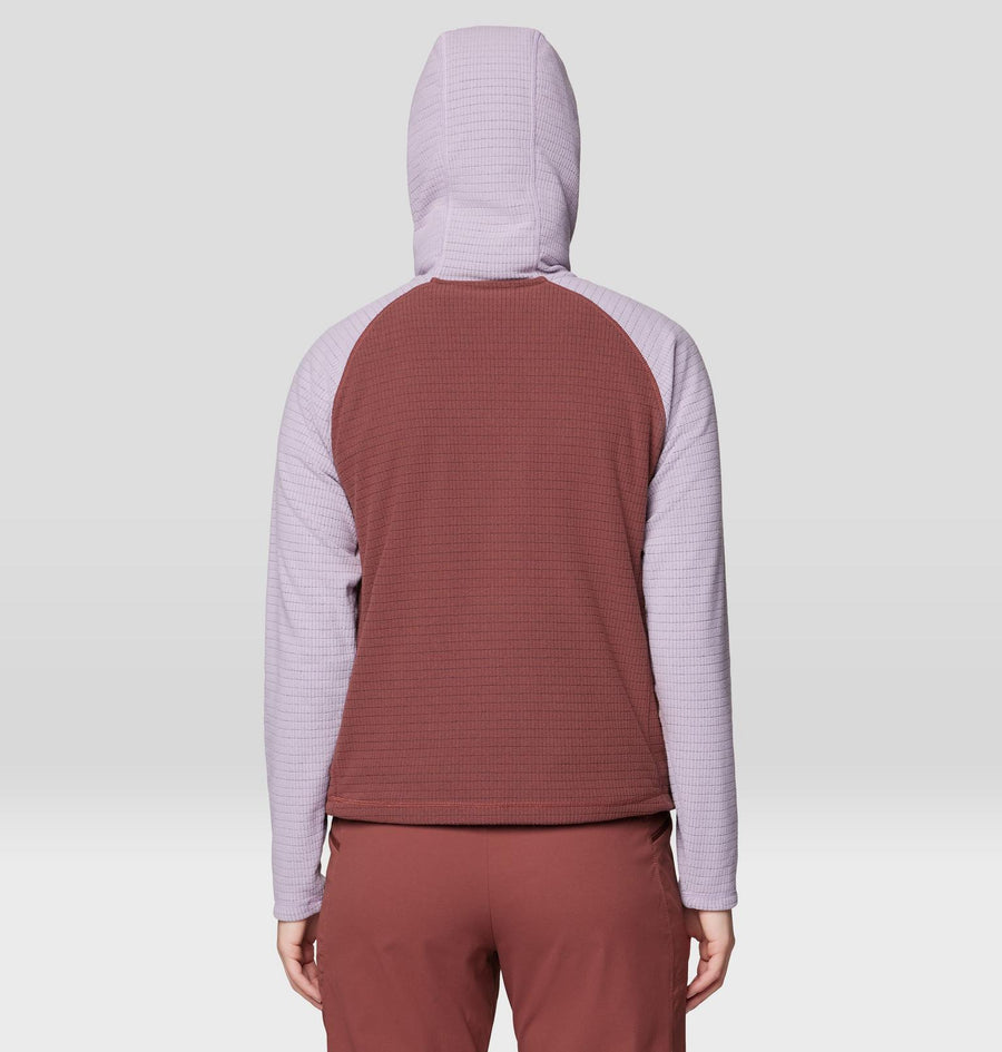 Person wearing a two-tone hoodie with purple sleeves and maroon body on a light gray background