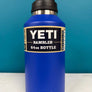Blue YETI Rambler water bottle with black lid on a white surface against a blue background