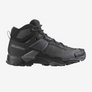 Side view of an all black shoe with grey accents that has Salomon logo on the side of the shoe against a white background. 