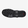 The sole of a shoe that is all black and has some red and grey accents against a white background.