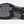 The sole of a shoe that is grey and black with the Keen logo in yellow in the middle against a white background.