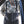 Person wearing camouflage jacket and black suspenders with 'Simms' branding.