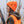 Person wearing a bright orange hat and vest outside.