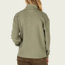 Back view of a person wearing a sage green long sleeve with brown pants against a white background.