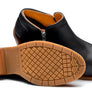 Pair of black boots laying on the ground to show the heel against a white background.