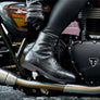 Person on a motorcycle wearing black boots.
