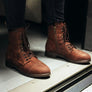 Person standing wearing brown boots.