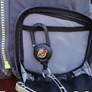 YakAttack single clip retractor clipped onto a backpack loop with pliers attatched to it