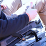 YakAttack single clip retractor clipped onto kayak seat and person using pliers attached to the retractor