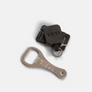 Yeti bottle opener next to a Yeti retractable clip against a white background. 