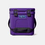 Purple cooler with light blue accents and a shoulder strap with Yeti logo on the front in light blue and dark purple.