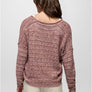 Back view of a person wearing a pink sweater and cream pants against a grey background.