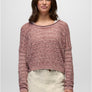 Person wearing a pink sweater with cream pants against a grey background.