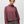 Person wearing a dark mauve sweater with grey pants against a white background.